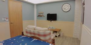 花蓮市にある日光森林親子民宿のベッドルーム(ベッド1台、椅子、テレビ付)