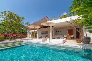 a swimming pool in front of a villa at Villa Pasir Putih in Candidasa