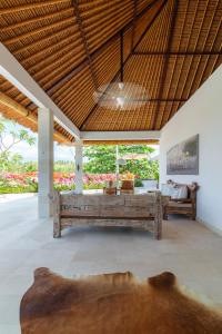 チャンディダサにあるVilla Pasir Putihのリビングルーム(ベンチ、テーブル付)