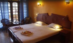 a bedroom with a large bed with two plates of food on it at Anitha's Garden Stay in Kovalam +22 photos