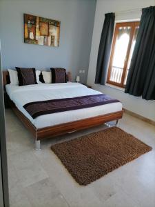 1 cama grande en un dormitorio con ventana en Le Sifah - Marina View Apartments & Villa, en As Sīfah