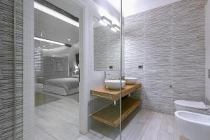 ein Badezimmer mit Waschbecken und Toilette und ein Bett in der Unterkunft MANDRIA APARTMENTS 1 2 in Bologna + 39 Fotos