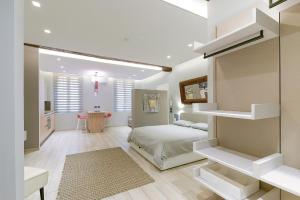 a white bedroom with a bed and a desk at MANDRIA APARTMENTS 1 2 in Bologna