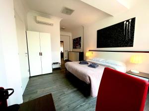 a hotel room with a bed and a red chair at Your House By Ale in Rome