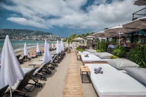 Sun Hotel By En Vie Beach في ألانيا: صف من كراسي الشاطئ والمظلات على الشاطئ