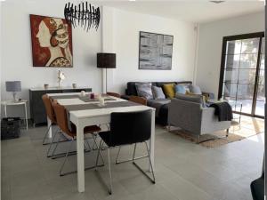 sala de estar con mesa, sillas y sofá en Sea views modern villa for relaxing holidays en Costa Teguise