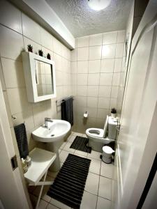 een witte badkamer met een toilet en een wastafel bij Laboria 102 & 103 in Harrismith