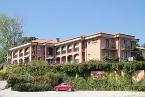 un coche rojo estacionado frente a un edificio en Albergo Ristorante San Biagio, en Montepulciano