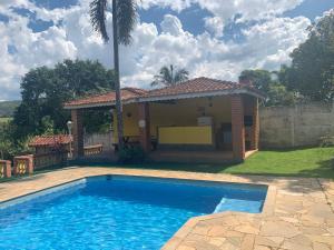 a swimming pool in front of a house at Chácara das Violetas in Atibaia