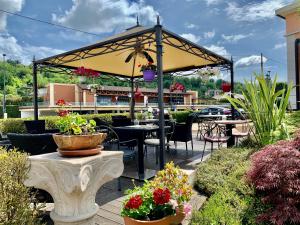 a patio with tables and chairs and a yellow umbrella at Locanda Al Bersò in Calco