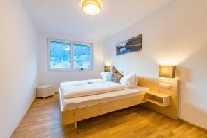 a bedroom with a wooden bed and a window at Apart Blasblei in Sankt Gallenkirch