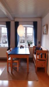 comedor con mesa azul y sofá en Lundtofthøj, en Aabenraa