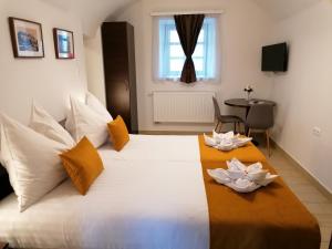 ヤースベレニにあるRiver Apartmanházのベッドルーム1室(白いベッド1台、ユリ2つ付)