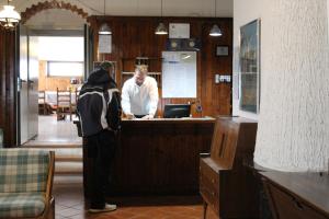 Ein Mann steht in einer Bar in einem Restaurant. in der Unterkunft Hotel La Piccola Baita in Monte Terminillo
