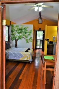 ein Schlafzimmer mit einem Bett mit einem Baum an der Wand in der Unterkunft Sanpopo Tree Top Cottage - A Gold Standard Tourism Approved Vacation Home in San Ignacio