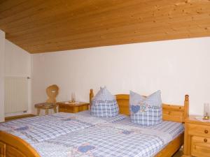 1 dormitorio con 1 cama con almohadas azules y blancas en Esingerhof, en Laufen