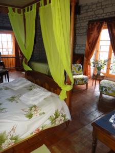 een slaapkamer met 2 bedden en groene gordijnen bij gîte du manoir des roches in Saires