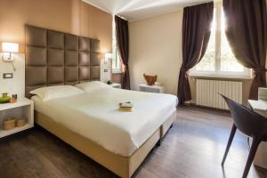 een slaapkamer met een groot wit bed en een bureau bij Villa Sylva & Spa in Sanremo