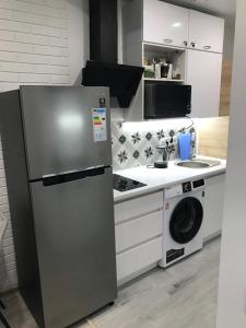 a kitchen with a refrigerator and a washing machine at Arcadia sky in Odesa