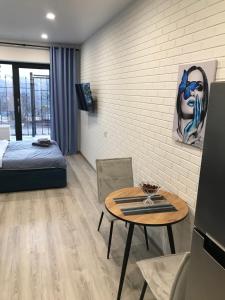 a room with a table and a bed and a table and chairs at Arcadia sky in Odesa