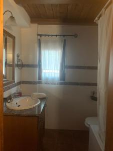 a bathroom with a sink and a toilet and a window at Apartamentos Rurales Peralta in Segura de la Sierra +73 photos