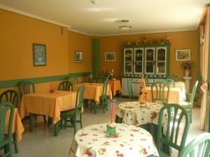 a restaurant with tables and chairs with yellow walls at Hotel Mataleñas in Santander