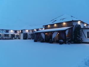 ein Hotel im Schnee in der Nacht in der Unterkunft Three Aces in Velikaya Dobronʼ