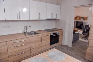 卡羅林卡的住宿－Apartmán Lydie，厨房配有白色橱柜和水槽
