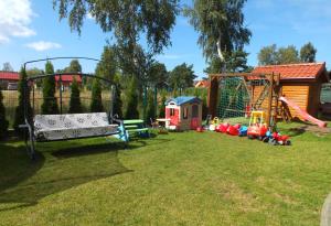 a yard with a playground with a swing at Willa Laura Rowy - Apartamenty nad morzem in Rowy