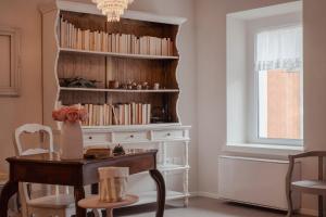 a room with a table and a book shelf with books at Il cantuccio sul Garda - Relais di charme in Cavaion Veronese