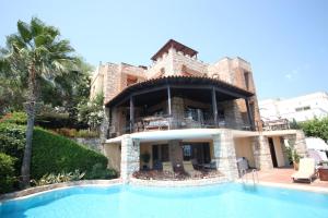 uma casa com uma piscina em frente em Villa Cosy em Yalıkavak