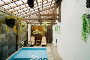 a swimming pool in a building with a wooden ceiling at OstiC House in Yogyakarta