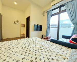 a bedroom with a large bed and a blue couch at 愛分享民宿 Love & Share House in Hualien City