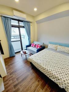 a bedroom with a bed and a couch at 愛分享民宿 Love & Share House in Hualien City