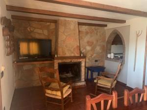 a living room with a tv and a fireplace at Apartamentos Rurales Peralta in Segura de la Sierra