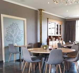 una sala da pranzo con tavoli, sedie e un dipinto di Hotel B - Boskapelhoeve a Buggenhout