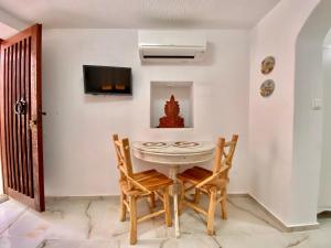 a dining room with a white table and chairs at Lion House II in Ioulida