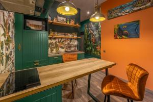 uma cozinha com armários verdes e uma mesa e cadeiras de madeira em Eco Apartments in french quarter em Kiev