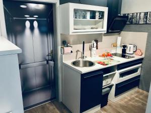 a small kitchen with a sink and a refrigerator at Wohnung mit Charme, Netflix in Rheinstetten