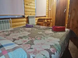 a bed with a blanket and pillows on top of it at Guesthouse Pushkina in Khuzhir