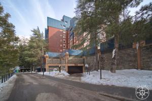a building on a street with snow on the ground at SALANA de Alma de Nieve in Baqueira-Beret