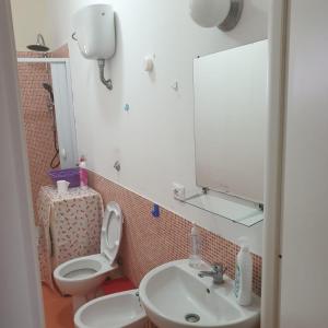 a bathroom with a toilet and a sink and a mirror at Suite La Rosa Dei Venti in Catanzaro
