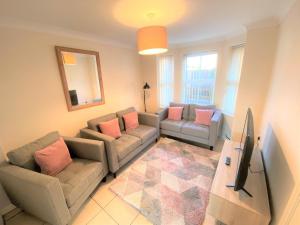 a living room with two couches and a mirror at Johnson Townhouse in Wellingborough