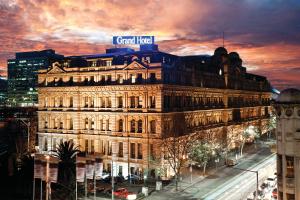 a large building with a sign on top of it at Grand Hotel Melbourne in Melbourne