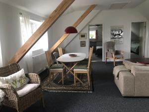 uma sala de estar com mesa e cadeiras em Strandsegård Ferielejlighed em Ølsted