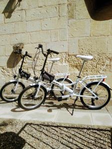 Dos bicicletas están estacionadas junto a una pared de ladrillo. en Masseria Cataldo en Corigliano dʼOtranto