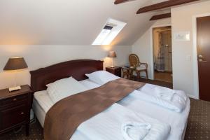 a bedroom with a large bed with a wooden headboard at Foldens Hotel in Skagen