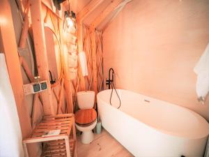 a bathroom with a bath tub and a toilet at Ałabajka jurta i camping in Wleń