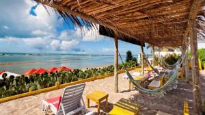 Una playa con sillas y una hamaca y el océano. en Casa na Barra de São Miguel Barra Mar, en Barra de São Miguel