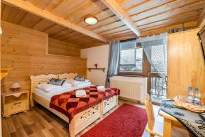 a bedroom with a bed and a desk and a window at Willa Cztery Pory Roku in Kościelisko